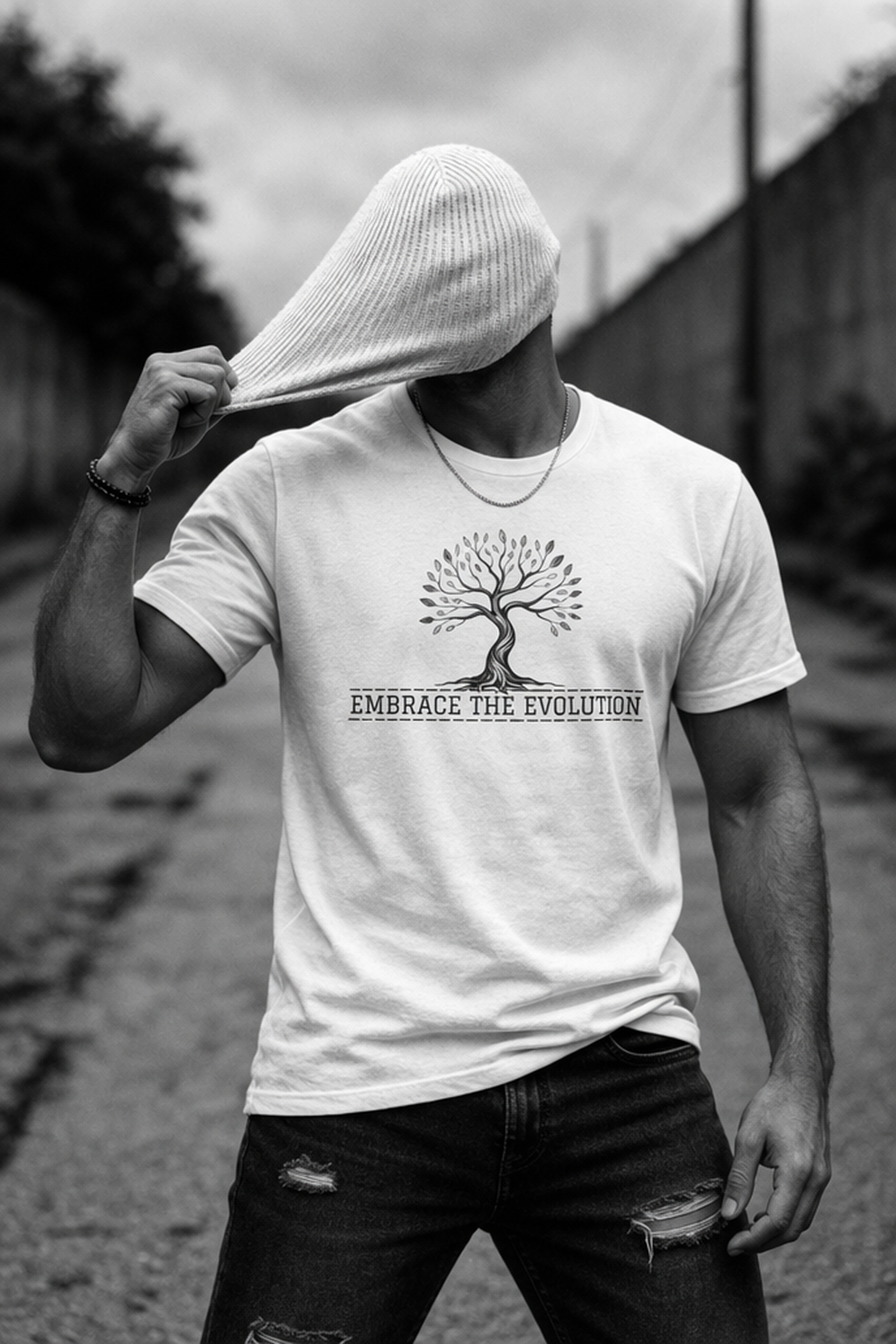 Person wearing a white t-shirt with a tree design and text outdoors.